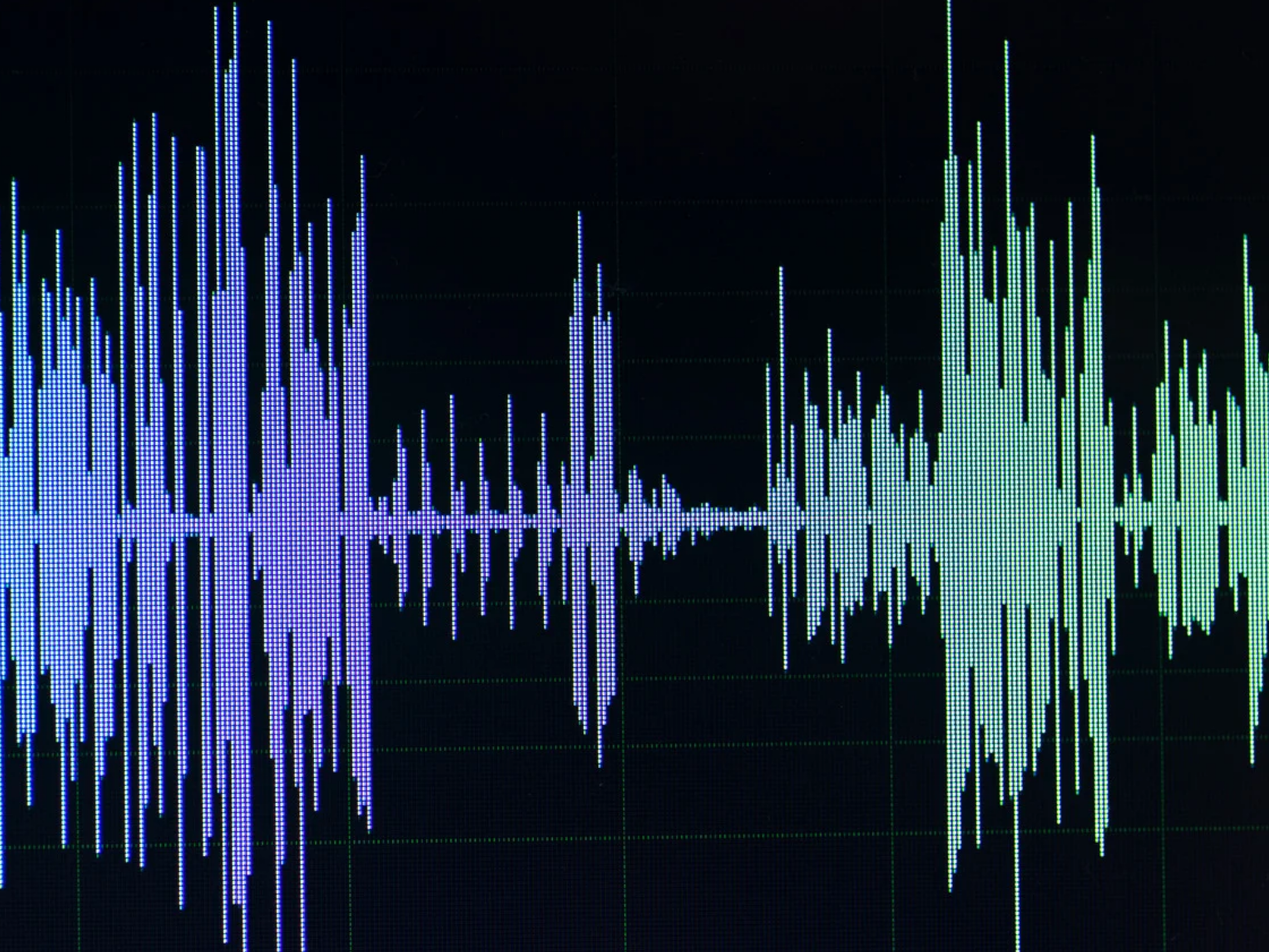 Digital audio waveform displayed on a screen, featuring varying amplitudes in shades of blue and green.